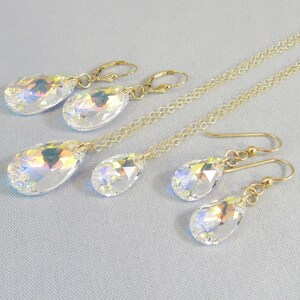 Pu&ograve; includere: Un set di collana e orecchini a catena dorata con ciondoli di cristallo a forma di lacrima iridescenti.