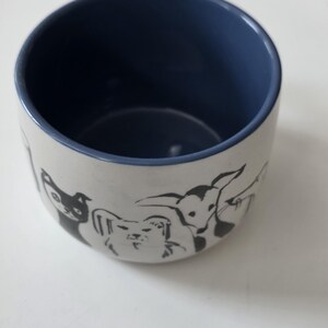 May include: A set of three ceramic canisters with lids. The canisters are white with a textured surface and feature a black geometric pattern. The lids are black. The canisters are of varying sizes.