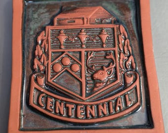 Firmado por Erika Bonner de Pensilvania. Azulejo de arte en arcilla con diseño en relieve del centenario.