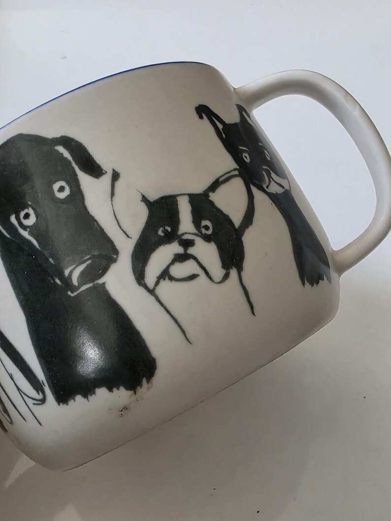 May include: A white ceramic mug with a black handle and the text "But First, Coffee" in a handwritten style. The mug is on a white surface. The mug is 4 inches tall.