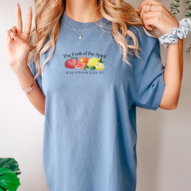 May include: A light blue t-shirt with a graphic of fruit and the text "The Fruit of the Spirit" and "GALATIANS 5:22-23".