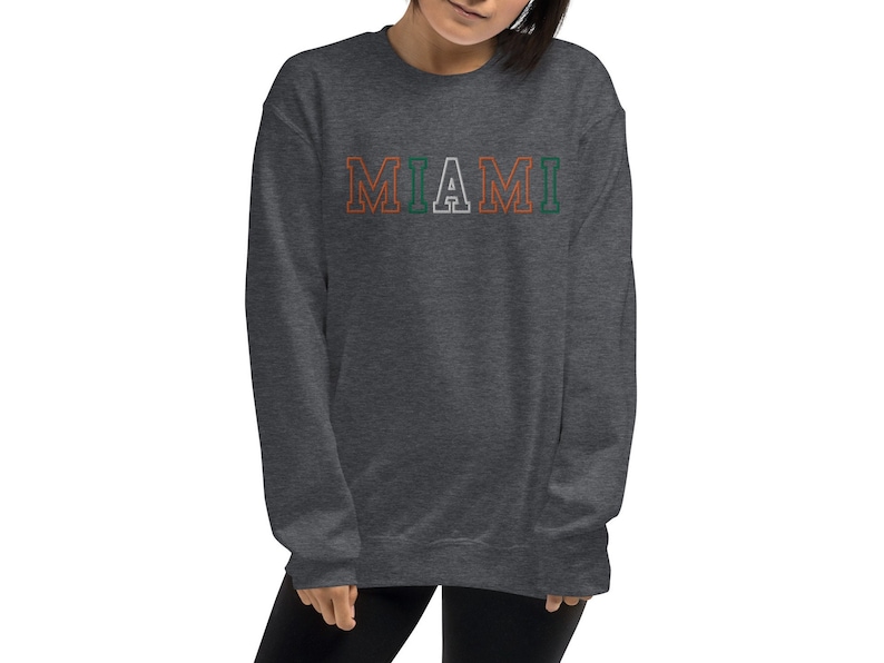 May include: A dark gray sweatshirt with the word "MIAMI" printed in white with orange and green outlines.