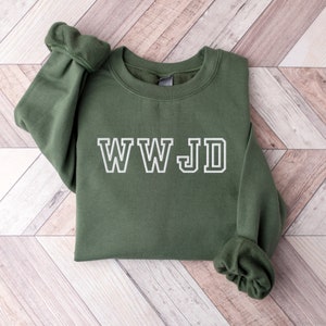 May include: A dark green sweatshirt with the text "WWJD" in white outlined letters.