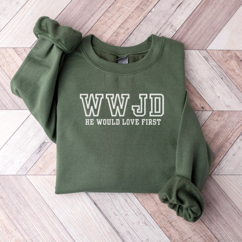 May include: A green sweatshirt with the text "WWJD HE WOULD LOVE FIRST" in white.