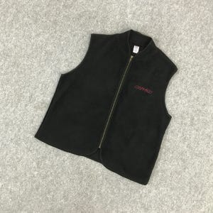 以下が含まれることがあります： 黒色のフリースベスト。フルレングスのジッパーと小さな赤い刺繍ロゴが付いています。 ベストはスタンドカラーとノースリーブのデザインです。 Gramicciのロゴが右胸に表示されています。