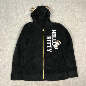 Pu&ograve; includere: Felpa con zip nera in pile con un design Hello Kitty. La felpa ha una grafica Hello Kitty bianca con un fiocco a pois leopardati e orecchie da gatto sul cappuccio.