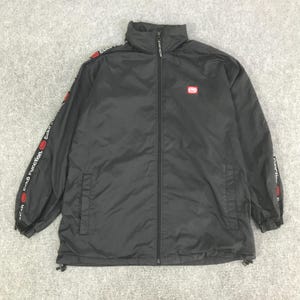 May include: A black zip-up jacket featuring a high collar and long sleeves with red and white Ecko Function branding along the arms. The jacket includes a small red Ecko logo on the left chest, a full-length front zipper, and adjustable drawstrings.