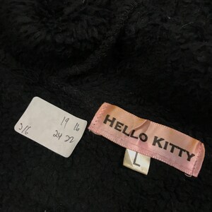 Pu&ograve; includere: Felpa con cappuccio in pile nero con un'etichetta rosa Hello Kitty e un'etichetta di taglia L. L'etichetta riporta anche le misure in pollici.