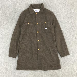 以下が含まれることがあります： ボタン留めの茶色のLeeジャケット。胸に2つのポケット、下に2つのポケットがあります。襟付きで、金色のボタンが付いています。Leeのロゴがラベルに表示されています。