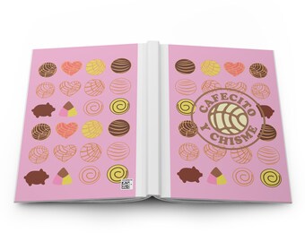 May include: An open notebook with a pink cover features a repeating pattern of pastries and a pig. The text "Cafecito y Chisme" is printed in a circle on the right page.