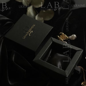 May include: Black jewelry box with a gold logo that reads "Lena Riabininia Jewelry" and the text "LAB packaging box UKRAINE".