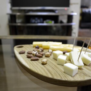 May include: A wooden serving board with a variety of snacks, including cheese cubes, breadsticks, and nuts.