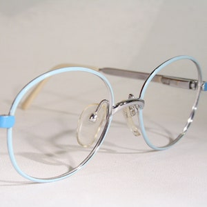 Op de afbeelding: Een bril met ronde glazen in lichtblauw en zilver.