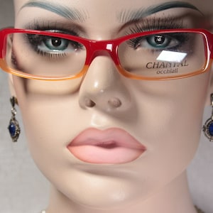 May include: Red and orange plastic framed glasses with the text "CHANTAL occhiali" on the right lens.