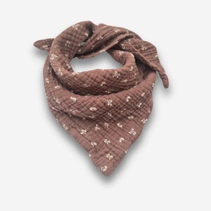May include: A brown bandana with a white floral pattern. The bandana is made of a soft, textured fabric.