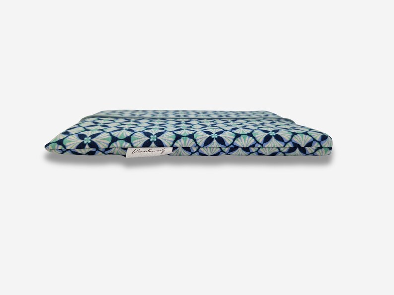 May include: A blue and green patterned fabric pouch with a white label that says "Wanderlust".