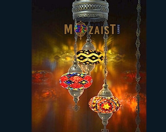 May include: A three-tiered Turkish mosaic chandelier with colorful glass globes. The globes are red, yellow, and black with geometric patterns. The chandelier is made of metal and has a chain.