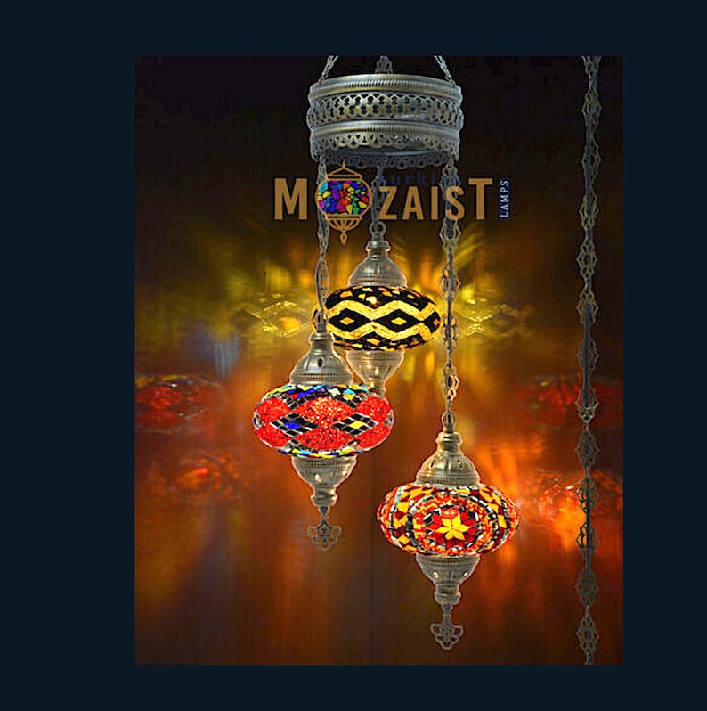 May include: A three-tiered Turkish mosaic chandelier with colourful glass globes. The globes are red, yellow and black with geometric patterns. The chandelier is made of metal and has a chain.
