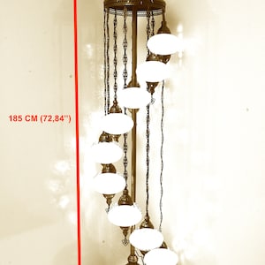 Może przedstawiać: Złota metalowa lampa stojąca o spiralnym wzorze z białymi szklanymi kloszami. Lampa ma 185 cm wysokości i 46 cm szerokości.