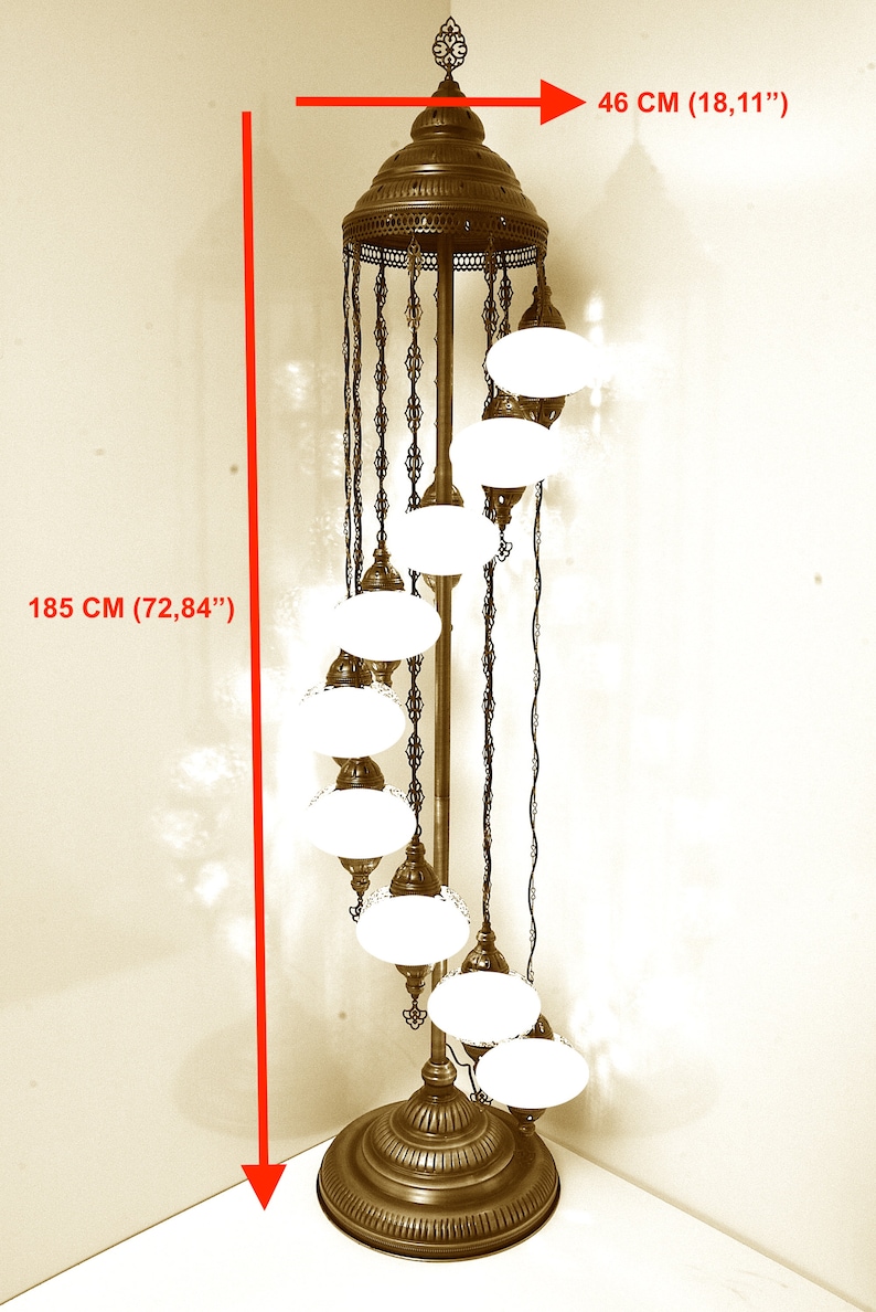 Może przedstawiać: Złota metalowa lampa stojąca o spiralnym wzorze z białymi szklanymi kloszami. Lampa ma 185 cm wysokości i 46 cm szerokości.