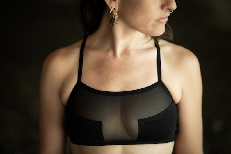May include: A black mesh and fabric sports bra with a racerback design.