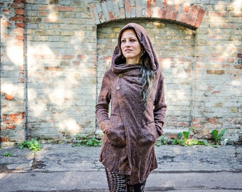 May include: A brown, textured, long-sleeve hooded jacket featuring an asymmetrical front closure with two visible buttons, a large cowl-style hood, and two front pockets. The garment has a heathered appearance and a slightly flared hemline.