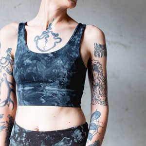 Puede incluir: Un top corto de color negro y gris con estampado tie-dye y cuello redondo. El top est&aacute; hecho de un tejido suave y el&aacute;stico y tiene un corte holgado.