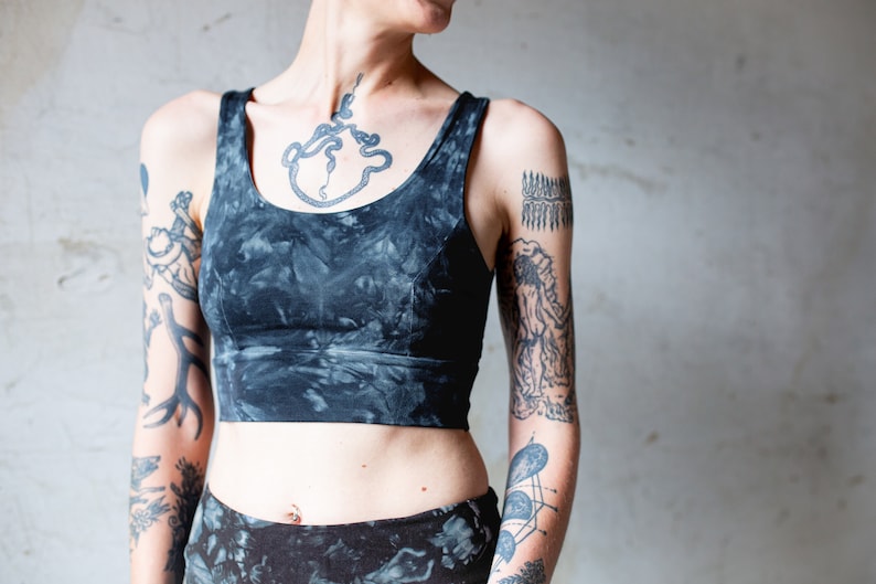 Puede incluir: Un top corto de color negro y gris con estampado tie-dye y cuello redondo. El top est&aacute; hecho de un tejido suave y el&aacute;stico y tiene un corte holgado.