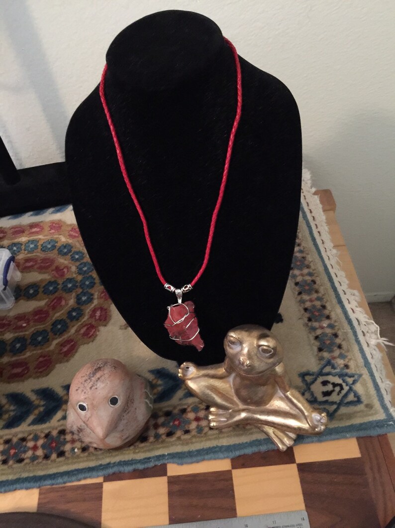 Strawberry Red Andara with a braided red leather necklace.