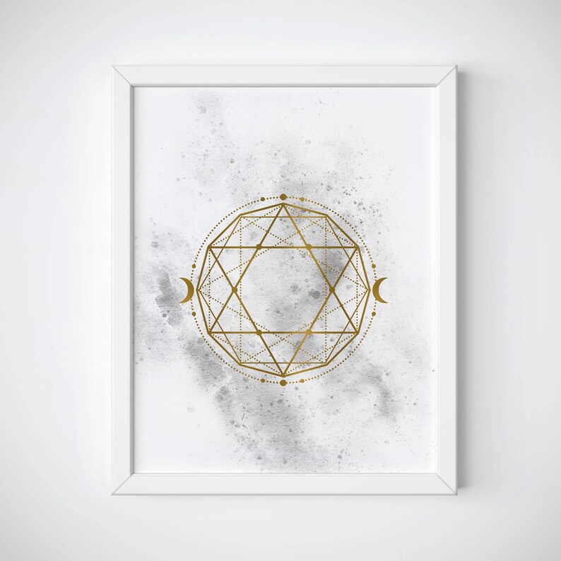 May include: A white framed print with a gold geometric design on a gray watercolor background. The design features a circle with a star inside and two crescent moons on either side.