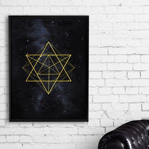 Op de afbeelding: Een zwart ingelijst print met een gouden geometrisch ontwerp op een donkerblauwe achtergrond met witte sterren. Het ontwerp is een stervorm met meerdere overlappende lijnen.