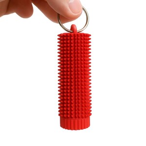 May include: A red, cylindrical keychain accessory with a textured, spiky surface. The keychain is held by a silver ring and is designed with a series of small, conical protrusions. The item is made of a flexible material.