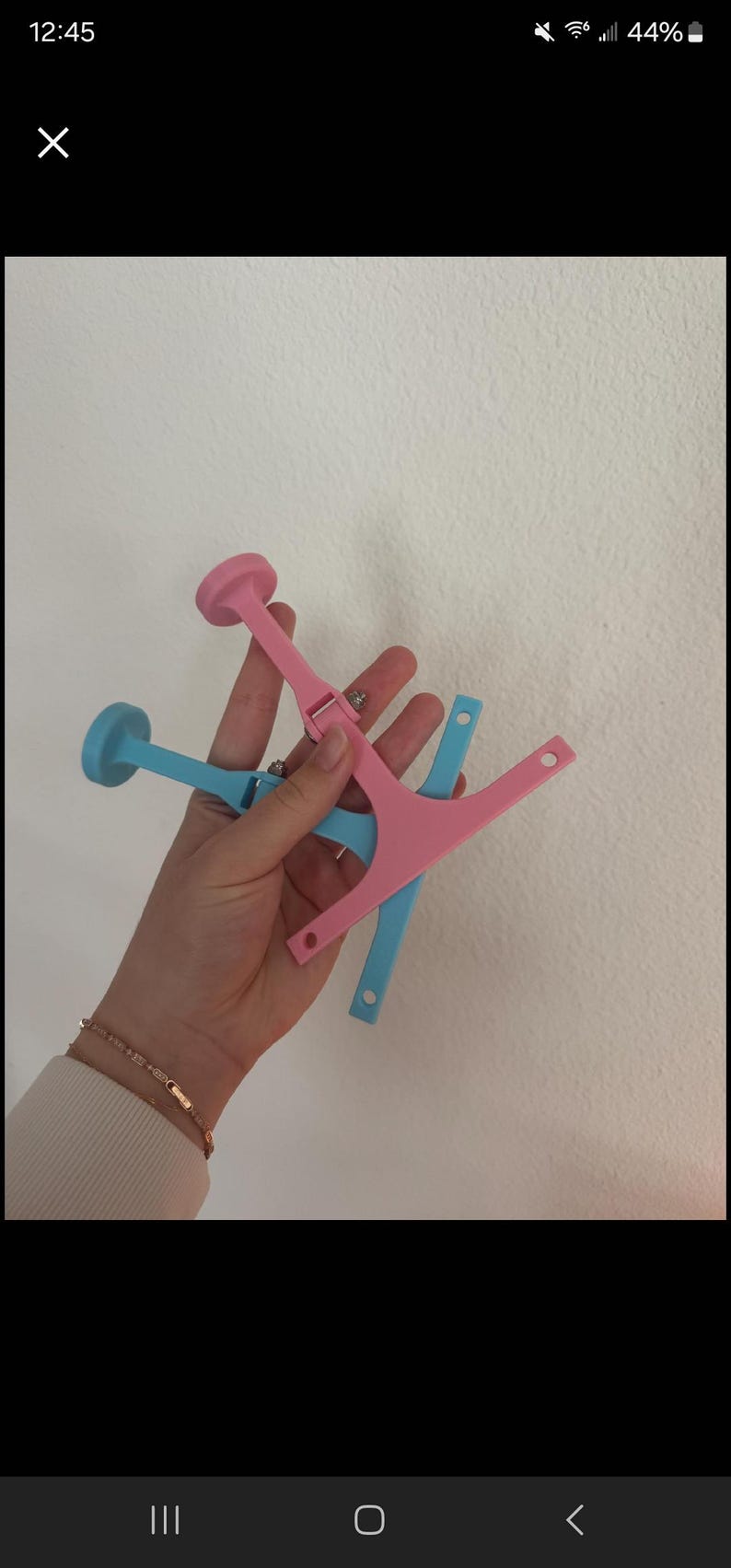 Puede incluir: Dos pinzas para el pelo de pl&aacute;stico, una rosa y otra azul, con un extremo redondeado y un dise&ntilde;o en forma de Y. Las pinzas se sostienen en una mano.