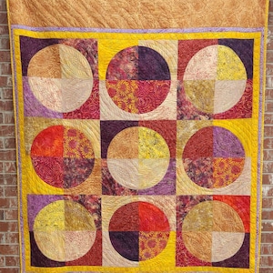 Batik Quilt in Sunset Colors of Yellow Orange Amber and Purple with ample quilting 62&quot; x 92&quot; twin size quilt