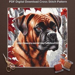 May include: A PDF digital download cross stitch pattern featuring a portrait of a brown Boxer dog with a black muzzle, set against a background of red autumn leaves and white snow. The text reads PDF Digital Download Cross Stitch Pattern.