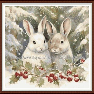 May include: Cross-stitch image of two rabbits in a winter scene. One rabbit is white, the other is tan. Holly with red berries frames the bottom, with a snowy evergreen background. A festive, seasonal design.