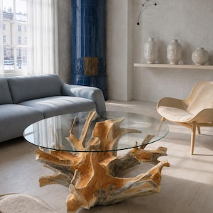May include: A round coffee table featuring a clear glass top supported by a natural, light-colored tree root base. The base displays intricate, organic wood textures and branching shapes, providing a sturdy foundation for the circular glass surface.