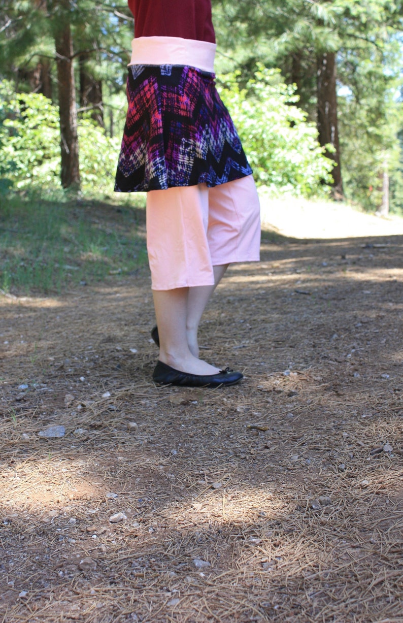 Skirted leggings (a skirt is attached to the bottom of the waistband, much like a skort).  Waistband and leggings are pale pink.  Skirt is black with pink and purple designs in a rough diamond pattern.