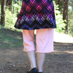 Back view showing the waistband, skirt, and leggings.  The skirt reaches just above the model's knees.