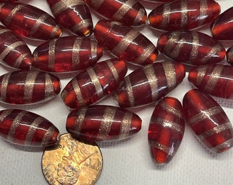 May include: A group of red and silver glass beads with a striped pattern. The beads are oval shaped and have a shiny finish.