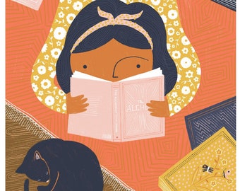 May include: A young person with brown skin and dark hair is lying on a patterned rug reading a book titled "The Alchemist". The rug is orange and yellow with a floral pattern. There are other books on the rug, including one titled "Mountain Sea & Woods". A black cat is curled up on the rug.