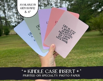 May include: A set of five colorful cards with inspirational quotes printed on them. The cards are designed to fit inside a Kindle case. The text on the pink card reads "Life is just a series of hurdles preventing you from reading your book".