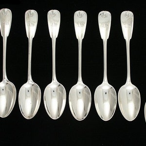 May include: Eight silver spoons with ornate handles. Each handle features an engraved design with the year "1918".