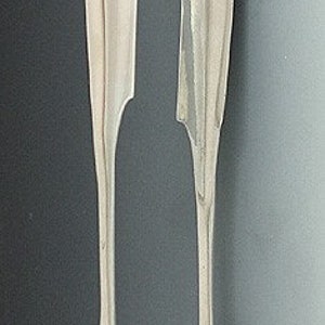 May include: Silver sugar tongs with a shell design on the ends.