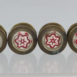 May include: Four antique brass drawer pulls with a red and white star design.