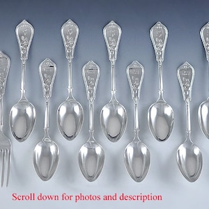May include: A set of 10 silver spoons and a fork with ornate handles. The spoons have a floral design and the handles are engraved with the words "The Best."