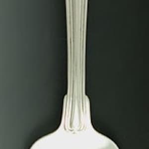 May include: Silver fork with a heart-shaped cut-out in the center of the tines. The handle is plain and has the initials "W.H." engraved on the front.