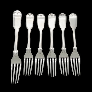 May include: Six silver forks with a heart-shaped design on the handle. The forks have a classic, elegant appearance, with a tined end for eating. The forks are arranged on a black background.