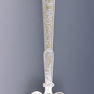 May include: A silver spoon with an ornate handle featuring a bird design and the text "East Lynne". The bowl of the spoon is also decorated with an intricate floral pattern.