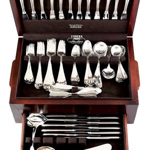 May include: A wooden box with a drawer containing a set of silver flatware. The box is open and the flatware is arranged in the top section. The flatware is labeled "Eureka Silverplate".